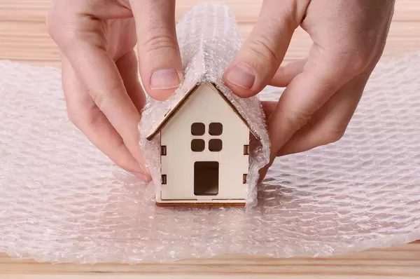 Man wrapping house in bubble wrap