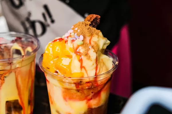 Mango Shake im Becher mit buntem Topping aus der Nahansicht