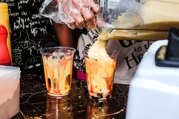 Mango shake wird in zwei Becher gefüllt