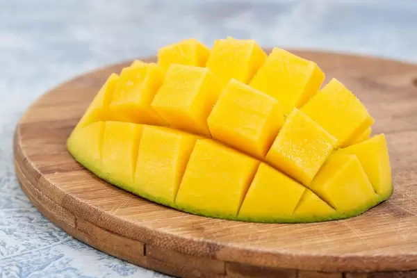 Mangofrucht als Igel angerichtet, liegt auf einer weiß-blauen Küchenzeile