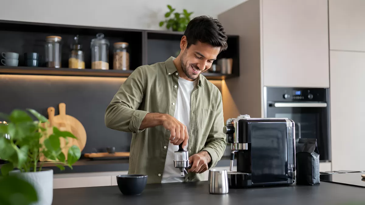 Mann bereitet Espresso in moderner Küche zu