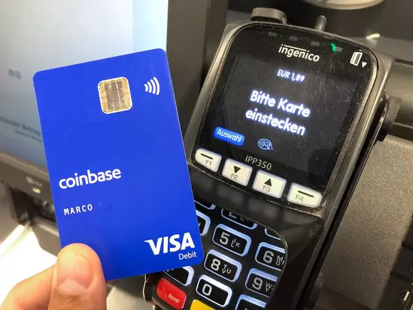 Mann bezahlt Bargeldlos im Supermarkt, mit Kryptowährung durch die Coinbase-Visakarte