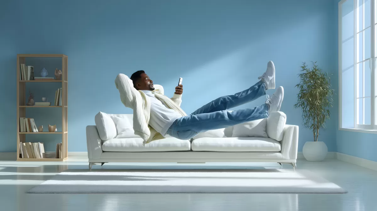 Mann entspannt auf Couch mit Smartphone in modernem Wohnzimmer