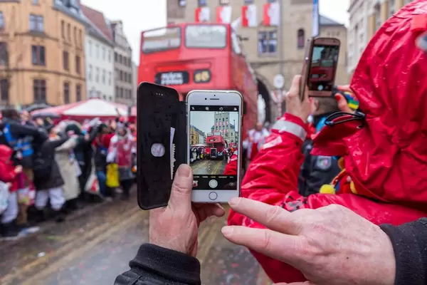 Mann fotografiert den Wagen von den Bläck Fööss (einer der erfolgreichsten Kölner Bands) mit seinem Smartphone beim Rosenmontagsumzug in Köln