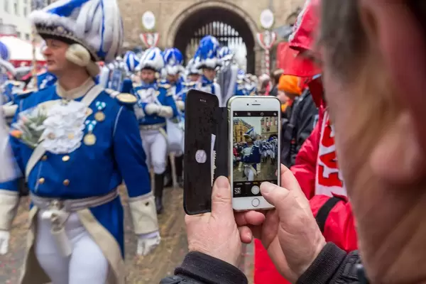 Mann fotografiert die Kölner Funken Artillerie blau weiß v. 1870 am Severinstor beim Rosenmontagsumzug in Köln