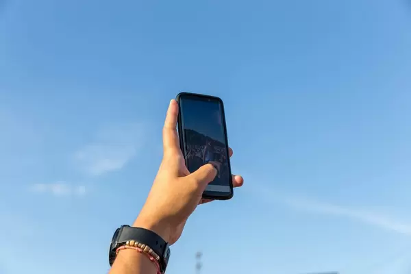 Mann fotografiert Fußballfans mit seinem Handy