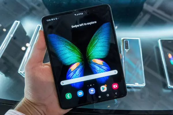 Mann hält das faltbare Handy Galaxy 5G von Samsung mit großem, faltbaren Infinity Flex Display in der Hand