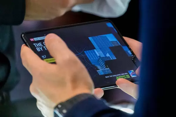 Mann hält das große faltbare Infinity-Flex-Display von Samsung Galaxy Fold 5G in der Hand und testet die Bildschirmqualität des Android-Handys