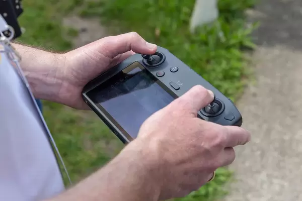 Mann hält den DJI Mavic 2 Smart Controller mit 5,5 Zoll Bildschirm und automatischer Verbindung zur Drohne