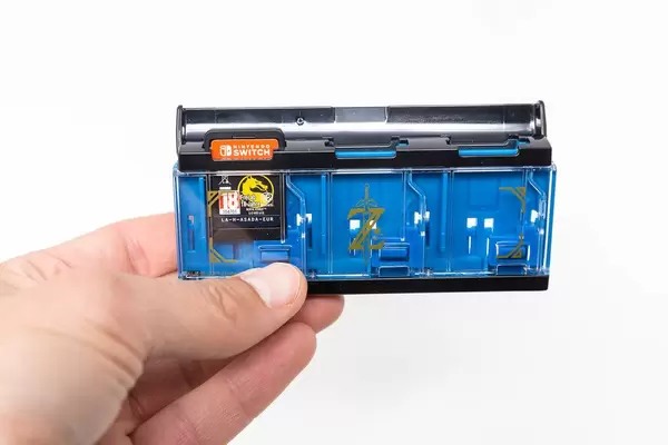 Mann hält den Zelda Pop & Lock Spielekartenhalter für Nintendo Switch in der Hand vor weißem Hintergrund