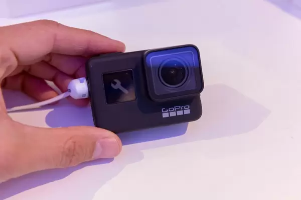 Mann hält die neue Action Kamera GoPro Hero 7 Black an der Photokina in Köln