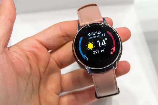 Mann hält die Smartwatch "Galaxy Watch Active 2" von Samsung, mit lokaler Temperaturanzeige in der Hand