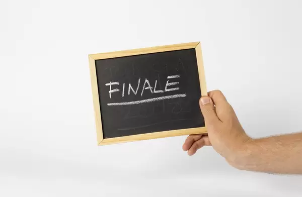 Mann hält ein Schild mit Aufschrift Finale