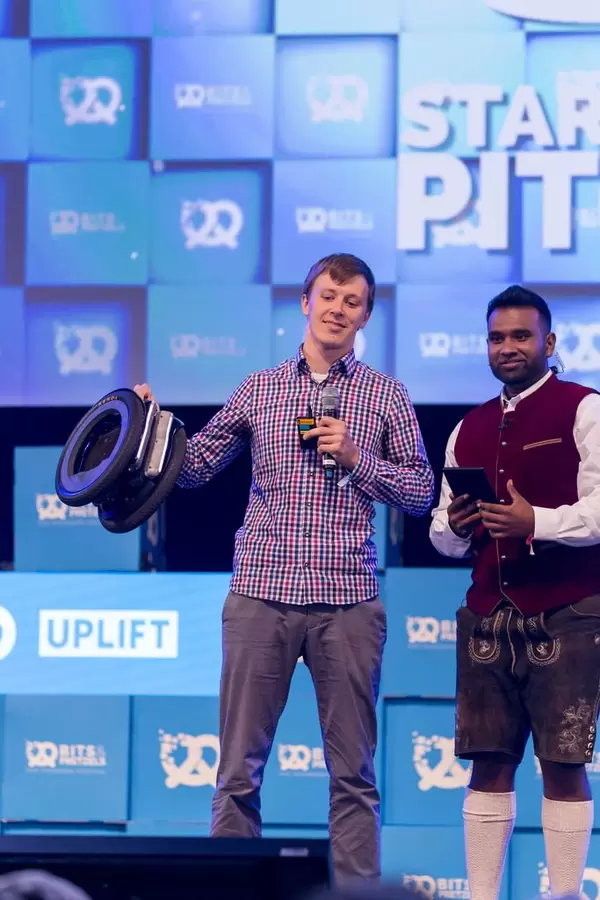 Mann hält seine Erfindung in der Hand beim Bits & Pretzels 2018