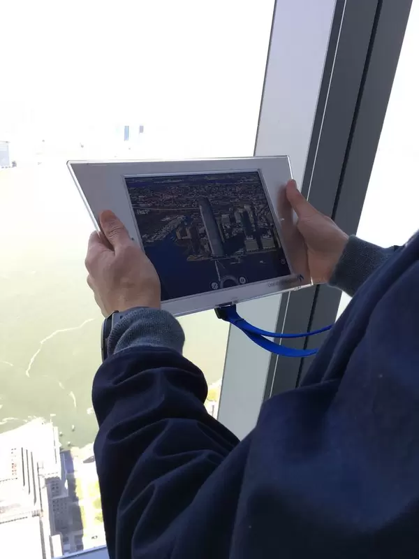 Mann hält Tablet mit einem Foto des Gebäudes Colgate Center in den Händen in Jersey City, USA