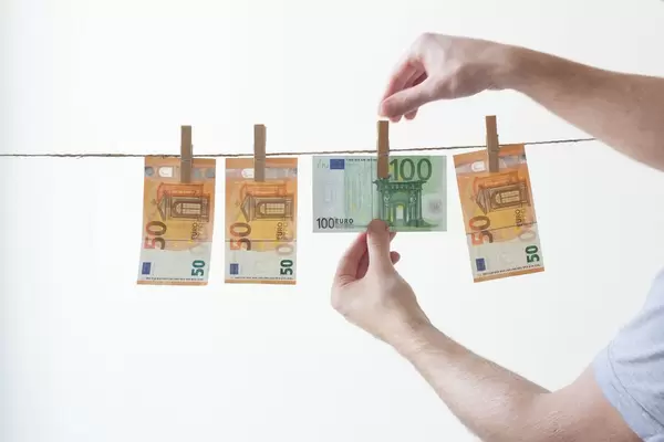 Mann hängt sein Geld an einer Wäscheleine auf