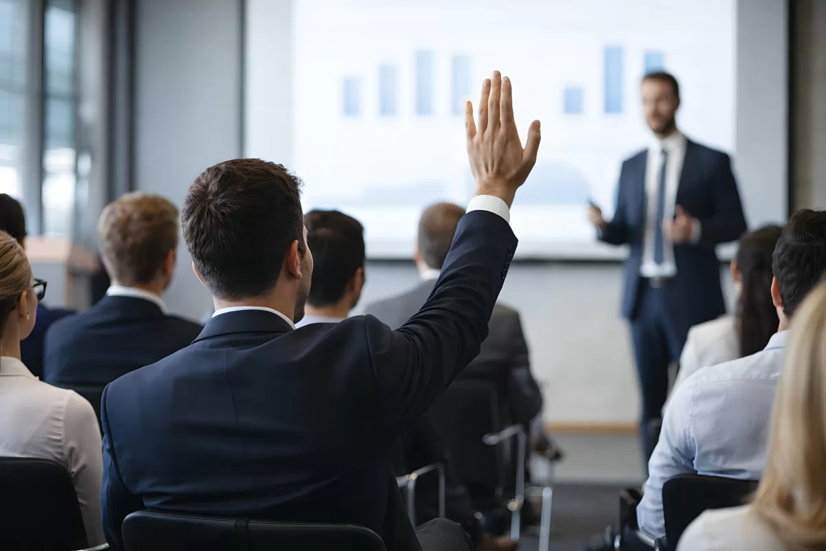 Mann hebt Hand bei Geschäftspräsentation im Konferenzraum