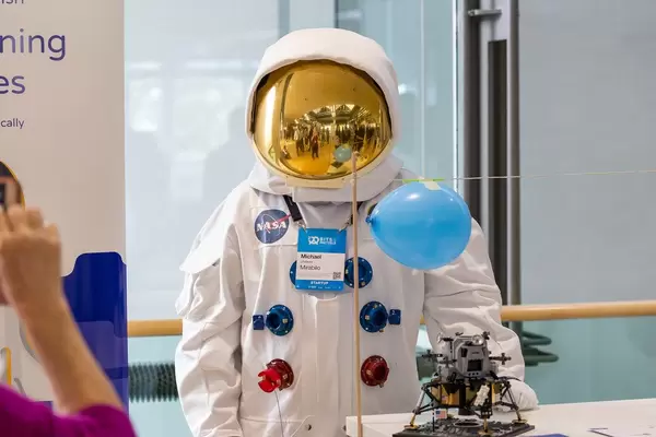 Mann im Astronauten-Kostüm am Startup-Stand der Lernsoftware Mirabilo