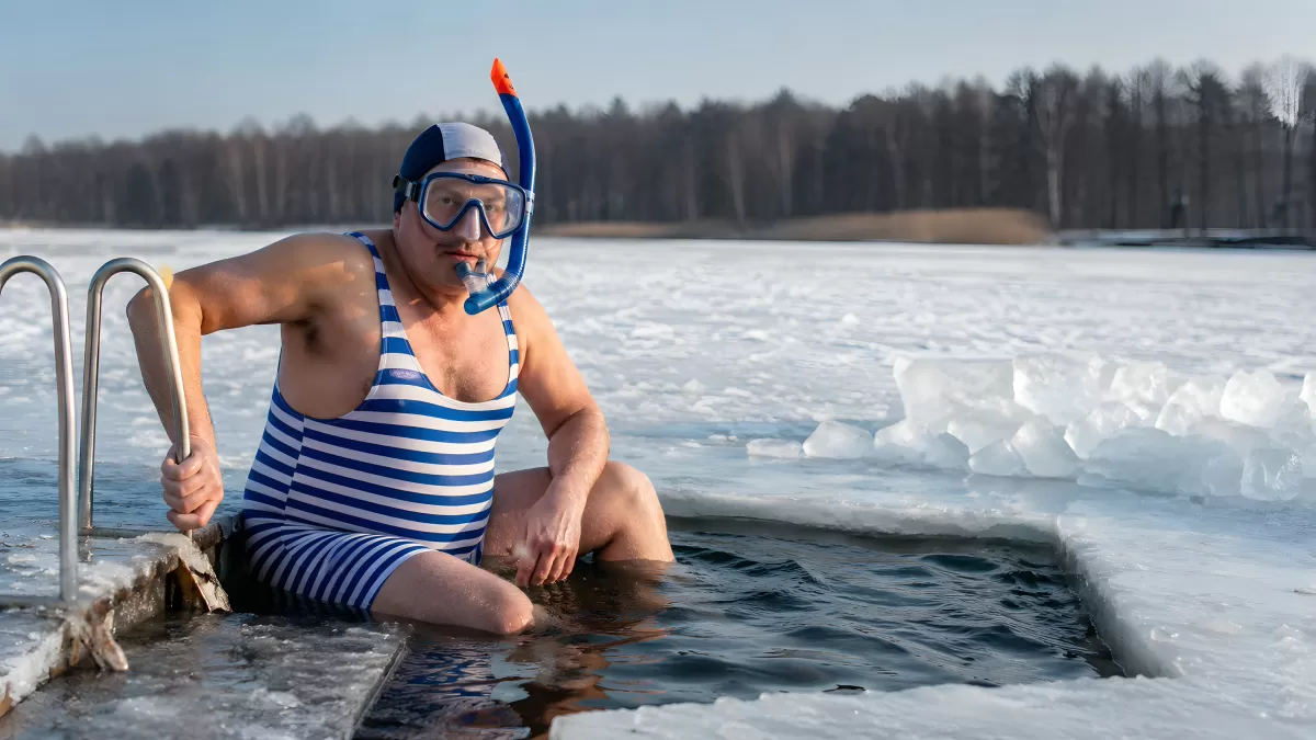 Mann im Badeanzug beim Eisschwimmen im Winter
