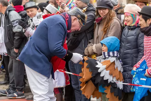 Mann in alter Feuerwehruniform gibt Jungen ein Geschenk - Kölner Karneval 2018