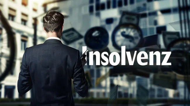 Mann in Anzug vor Gebäude mit Insolvenztext