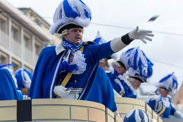 Mann in blau-weißer Uniform wirft Zuschauern Päckchen zu - Kölner Karneval 2018