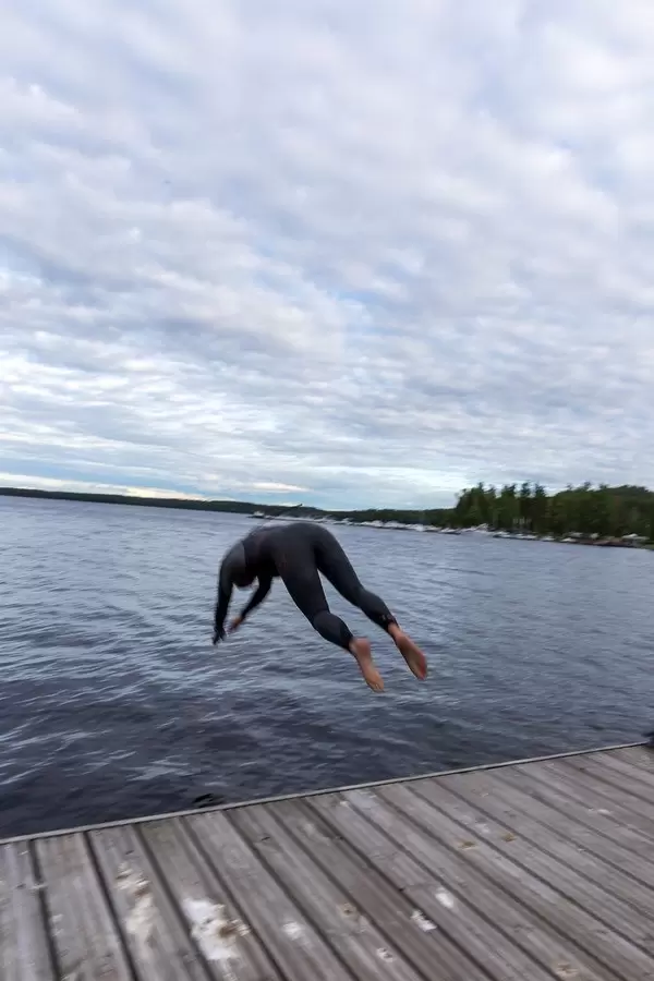 Mann in Taucheranzug macht einen Kopfsprung in den See Päijänne nahe Lahti in Finnland