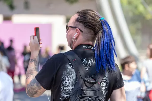 Mann mit Dreadlocks fotografiert mit seinem Handy