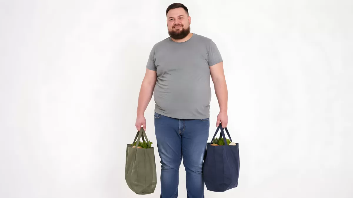 Mann mit Einkaufstaschen voller frischer Lebensmittel