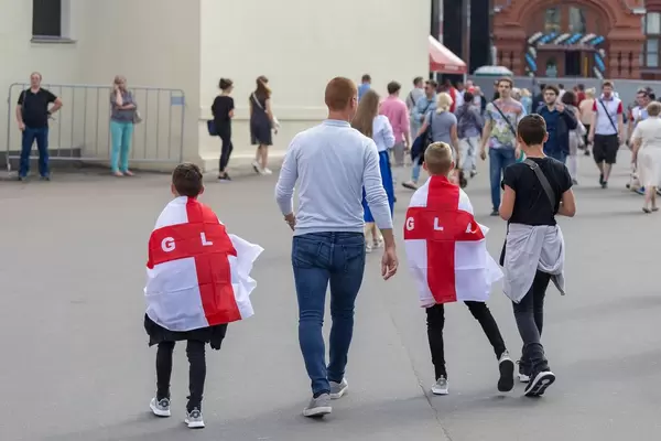 Mann mit Söhnen mit Flaggen von London auf den Rücken