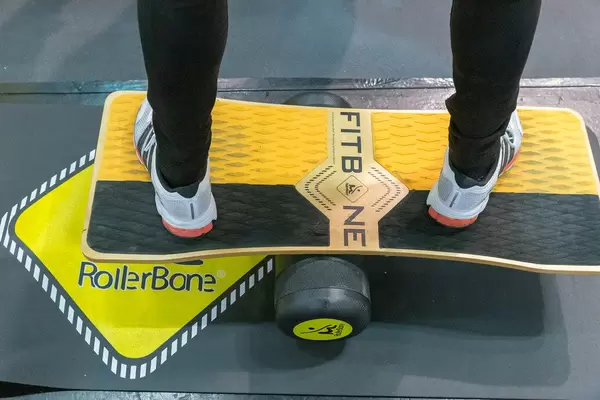 Mann probiert das RollerBone FitBone an der Fibo-Messe aus - ein Balanceboard für Boardsportler