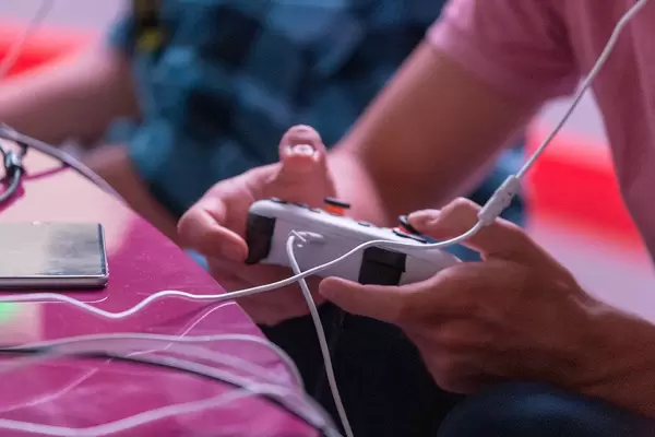 Mann spielt mit einem Google Stadia Controller auf dem Gamescom in Köln