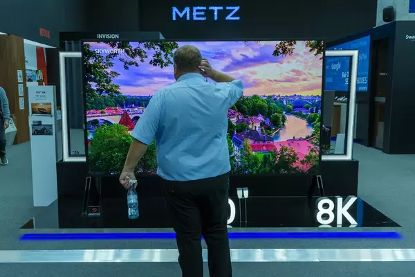 Mann steht vor dem Metz 120 Zoll 8K LCD-Fernseher mit 3m Bildschirmdiagonale