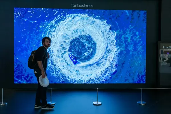 Mann steht zum Größenvergleich vor dem riesigen Samsung-Bildschirm "The Wall", mit LED Chip und Black Seal-Technologie