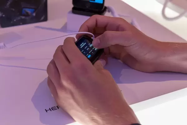 Mann testet in Händen die neue Action Kamera GoPro Hero 7 an der Photokina in Köln