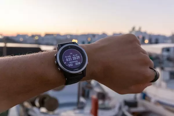 Mann trägt die Laufuhr von Garmin, mit Anzeige von Sonnenaufgang, Sonnenuntergang und Dämmerungszeit