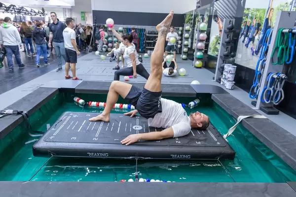 Mann trainiert an einem ReaxBoard - ein neues Neuromuskuläres Trainingsgerät an der Fibo-Messe in Köln