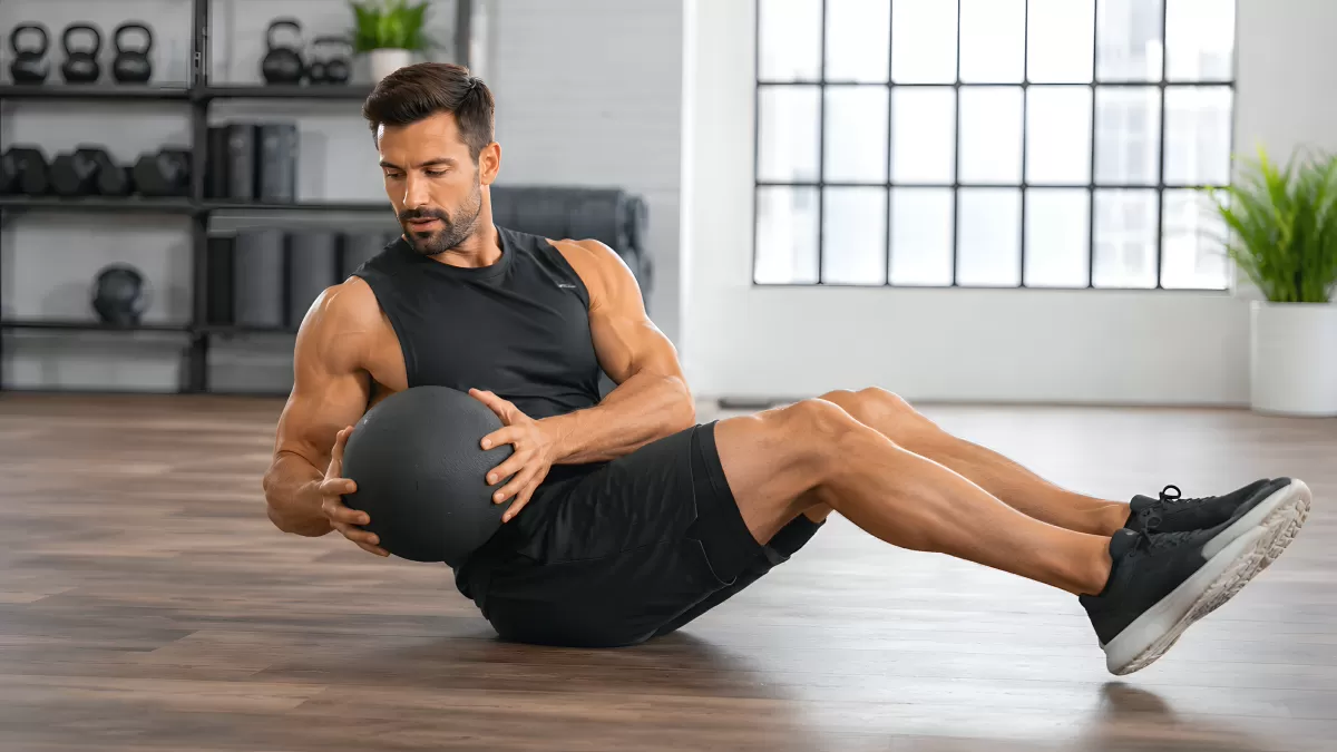 Mann trainiert mit Medizinball beim Sit-up im Gym