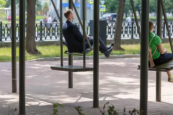 Mann und Frau auf großen Schaukeln in einem Park