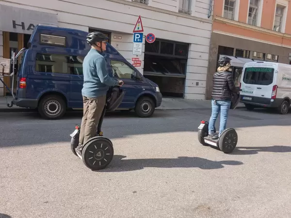 Mann und Frau fahren auf Segways durch die Stadt - München