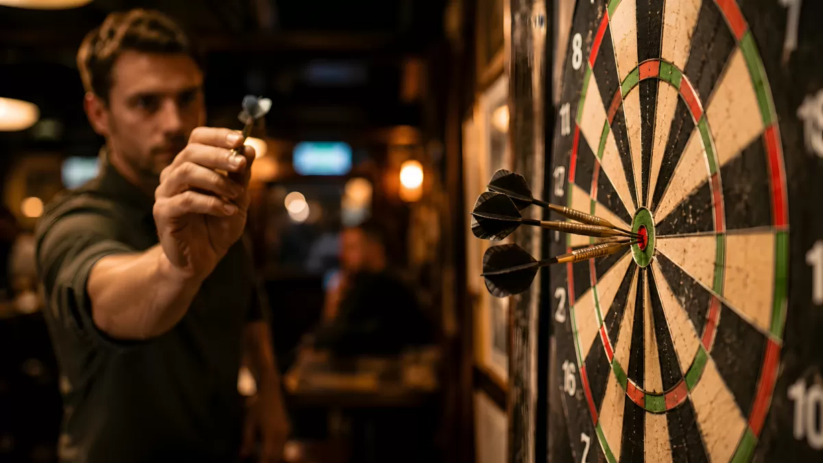 Mann zielt mit Dartpfeil auf Scheibe in Bar