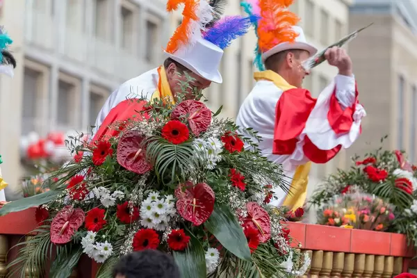 Männer im Wagen des Festkomitee des Kölner Karnevals 1823 werfen den Zuschauern Blumen zu - Kölner Karneval 2018