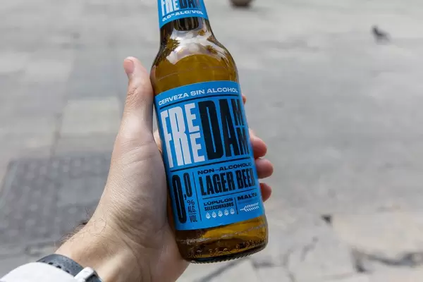 Männerhand hält alkoholfreies Lagerbier "Free Damm" aus Malta