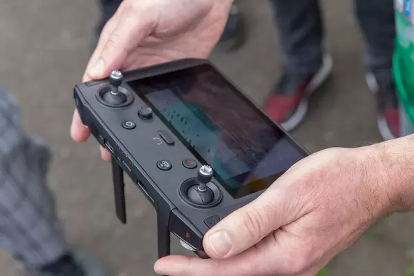 Männerhand hält die Fernsteuerung DJI Mavic 2 Smart Controller mit großem Display