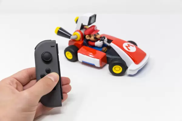 Männliche Hand drückt ein Button auf Nintendo Switch, um das Rennen mit dem Mario Kart zu starten