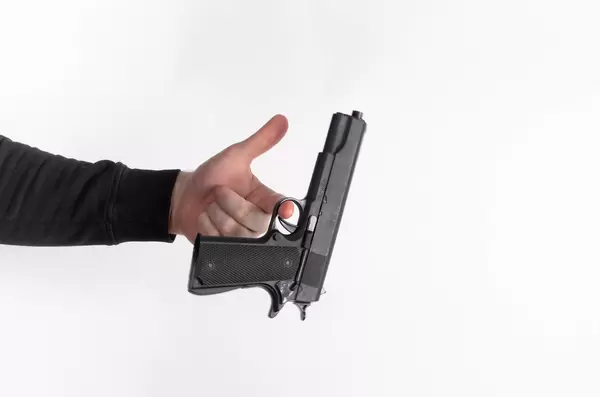 Man's hand holding gun, isolated on white