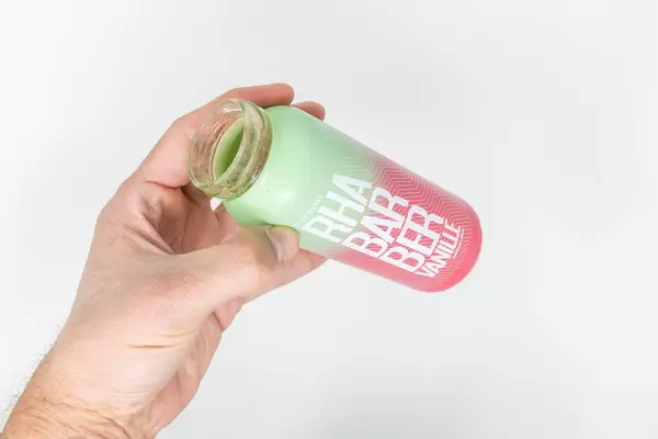 Man's hand holds an empty bottle of rhubarb-vanilla smoothie launched by true fruits as a special spring edition and already sold out