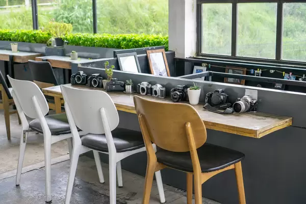 Many different Cameras on a Wooden Table as Decoration at a Coffee Shop