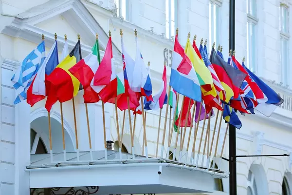 Many flags on a building, including: Belgium, Greece, USA, UK, Italy, France, Russia, Austria, Germany (Flip 2019)
