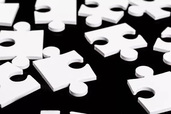 Many pieces from one white mosaic on black background